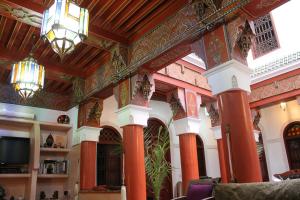 Habitación con columnas de color naranja y techo. en Riad Souad Marrakech, en Marrakech