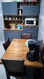 a wooden table in a kitchen with a microwave at Casa aconchegante in Mendanha
