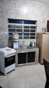 a kitchen with a sink and a microwave in it at Casa aconchegante in Mendanha +2 photos