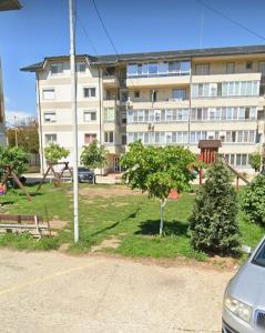 an apartment building with a park in front of a building at Flat Colina Magurii Bacau in Măgura