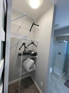 Ein Badezimmer mit begehbarem Kleiderschrank inklusive Handtüchern und Dusche in der Unterkunft Comfortable and Beautiful Brand-New Suite BSMT-Two Bedroom, Two Washrooms in Calgary