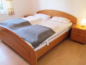 a large bed with a wooden frame in a bedroom at Ferienwohnung im Erdgeschoss in Neßmersiel in Neßmersiel