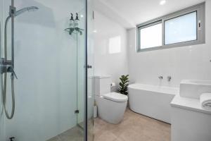 a bathroom with a toilet and a sink and a shower at Centrally Located Pymble Apartment in Pymble +12 photos