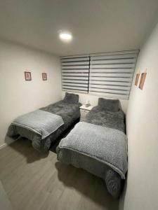a bedroom with two beds and a window at Departamento nuevo moderno y elegante in Viña del Mar