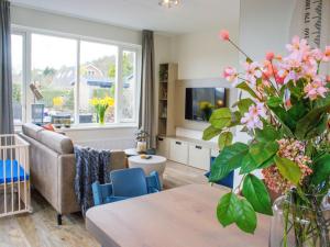 Una sala de estar con un sofá y una mesa con flores. en Holiday Home in Noordwijk near the Beach, en Noordwijk aan Zee