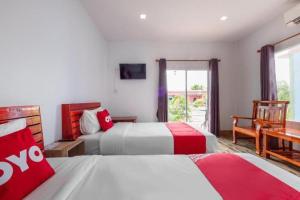 um quarto de hotel com duas camas e uma janela em OYO 1044 Vassana ResortÃ¢â‚¬â€¹ em Sattahip