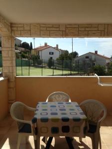 einen Tisch und Stühle mit Blick auf einen Tennisplatz in der Unterkunft Apartments Villa Kristina in Pula