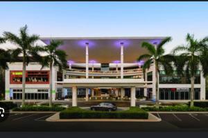 sky view apartments في سان خوان: سيارة متوقفة أمام مبنى فيه أشجار نخيل