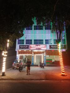 a man standing in front of a building at night at Family Hotel Stay In Hotel AV Priya Rajgir in Rājgīr +22 photos