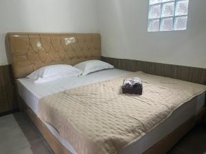 a bed with a purse sitting on top of it at Dr Stable Villa in Barukupa