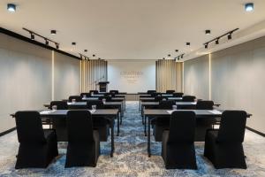 乔治市Citadines Connect Georgetown Penang的配有桌椅和讲台的会议室 更多37张照片