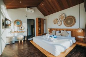 a bedroom with a large white bed and wooden floors at Skylake Villa in Kubupenlokan +87 photos