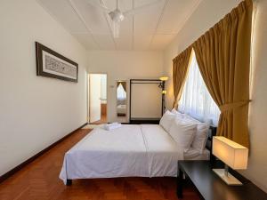a bedroom with a white bed and a window at PRIME Location - 5 Mins Walk to Shops & Eateries! in Tanjung Bungah