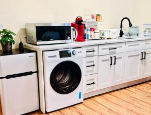 a kitchen with a washing machine and a microwave at Cozy 2 beds Spacious rooms,Close to transit in Vancouver