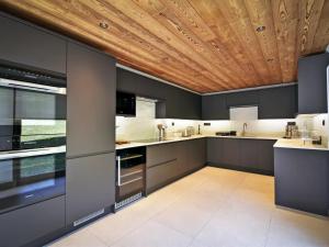 a kitchen with gray cabinets and a wooden ceiling at Chalet rénové avec sauna, salle de sport et navette gratuite - FR-1-613B-50 in Saint-Martin-de-Belleville