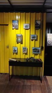 a yellow wall with a table with pictures on it at MOTO Inn URUBICI in Urubici