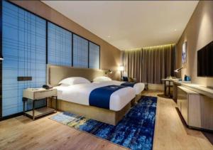 Voodi või voodid majutusasutuse Echarm Hotel Guiyang Airport Outlet Store toas