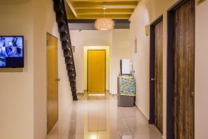 a hallway with a yellow door and a yellow elevator at Plumeria 4BR Garden House by uBook in Butterworth