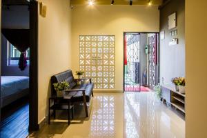 a room with a chair and a table and a bed at Plumeria 4BR Garden House by uBook in Butterworth