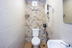 a bathroom with a toilet and a sink at Plumeria 4BR Garden House by uBook in Butterworth +31 photos