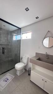 a bathroom with a toilet and a sink and a shower at Mansão Moraes - em Itacimirim Linha Verde in Camacari +4 photos