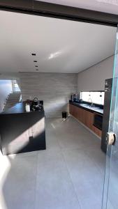 a large kitchen with a sink and a counter top at Mansão Moraes - em Itacimirim Linha Verde in Camacari