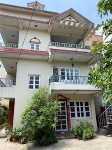 Casa blanca grande con ventanas y balcón en Tranquil Kathmandu Apartment, en Katmandú