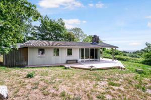 a small white house with a large deck at Nice Home In Knebel With 3 Bedrooms in Knebel