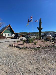 a landscaping with two flags and a cactus at Black Canyon Campground Modern Sleeping Pods Tiny Homes in Black Canyon City