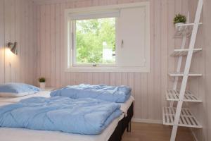 Un dormitorio con dos camas con almohadas azules y una ventana. en Stunning Home In Knebel With 4 Bedrooms And Wifi, en Knebel
