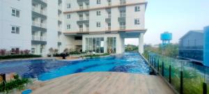 a swimming pool in front of a building at Studio Apartment at Suncity Residence Sidoarjo near Suncity Mall By Travelio in Sidoarjo