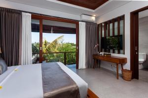 a bedroom with a bed and a desk and a television at Samtana Villas in Ubud +37 photos