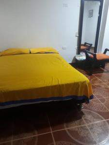 a bed with a yellow blanket on it in a room at Joananre in Ríohacha