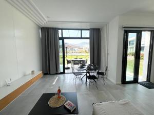 uma sala de estar com mesa e cadeiras e uma sala de jantar em Relaxed Coastal Stay with Poolside Access Great Amenities em Ayios Nikolaos