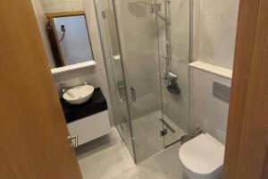 um banheiro com chuveiro, vaso sanitário e pia em Relaxed Coastal Stay with Poolside Access Great Amenities em Ayios Nikolaos mais 28 fotografias