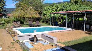 a swimming pool in a yard with a table at sleepy hollow guesthouse in Pantai Cenang