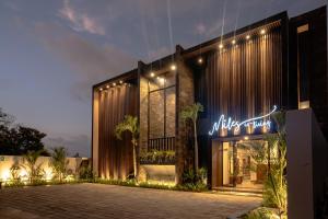 a building with a neon sign in front of it at Miles Coliving Bali, close to Seminyak and Canggu in Kerobokan