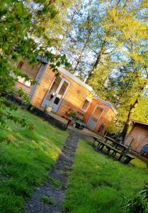 a wooden house with a picnic table in front of it at Knus huisje in het bos in Beekbergen