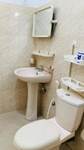 Un baño con inodoro, lavabo y espejo. en Siri Tourist Holiday Home, en Hikkaduwa 14 fotos más
