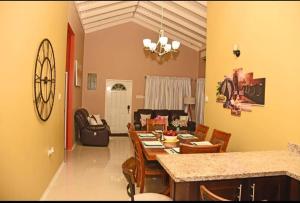 a kitchen and living room with a table and chairs at Irie Smart Villa 2 in Falmouth