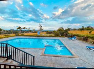 a large swimming pool with blue water at Irie Smart Villa 2 in Falmouth