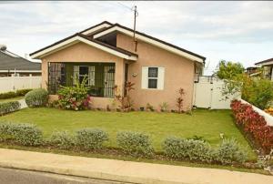 a house with a green lawn in front of it at Irie Smart Villa 2 in Falmouth