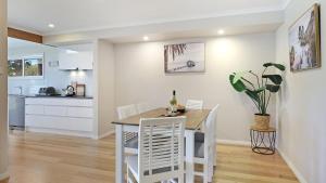 a kitchen and dining room with a table and chairs at Coastal Bungalow in Callala Bay