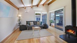 a living room with a couch and a fireplace at Coastal Bungalow in Callala Bay