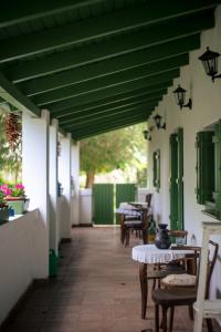 a patio with tables and chairs and a green ceiling at Kisparaszt Vendégház in Zákányszék +10 photos
