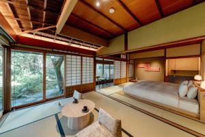 a bedroom with a large bed and windows at The Villa Higashiyama Roji Kazeno Heritage formaly HOTEL VMG VILLA KYOTO in Giommachi
