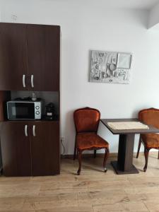 a kitchen with a table and chairs and a microwave at Old town villa superior studio in Sibiu