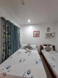 a bedroom with two twin beds and curtains at Dreamstay Hostel in Moalboal