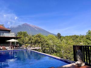 una piscina con una montaña al fondo en Puri Karang Besakih, en Menanga