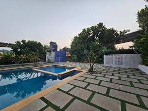 a swimming pool in the middle of a yard at JenJon Best Retreat Chalets at Sparsh Karjat Resort with optional SWIMMING POOL in Karjat
